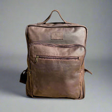 Load image into Gallery viewer, A brown leather laptop backpack with multiple compartments, including a front pocket zipped closure, displayed against a neutral background.